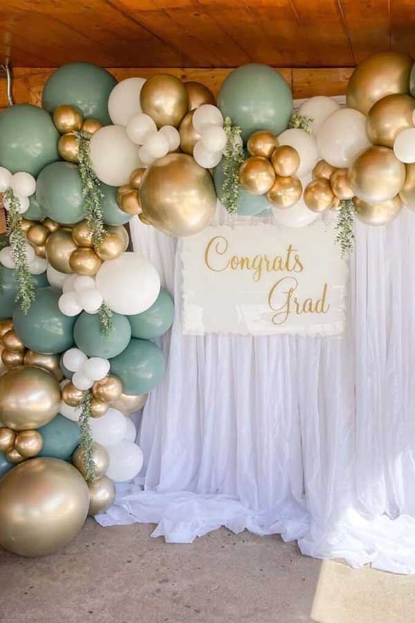 23 Picture-Perfect Graduation Party Backdrop Ideas That Will Wow Your Guests 11 Neutral Curtain Backdrop With Gold Congrats